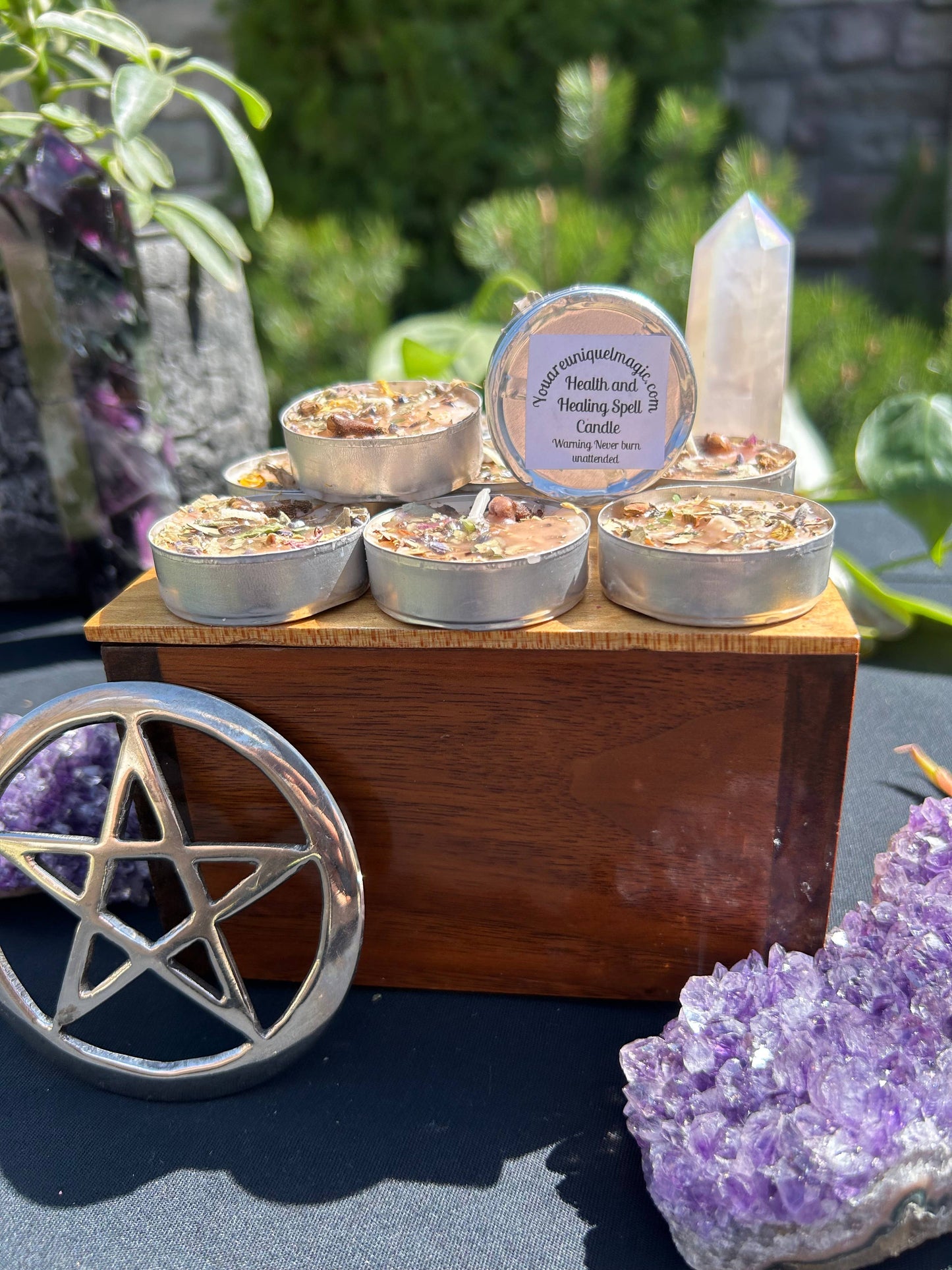 Candle set on a wooden stand with crystals and a pentacle symbol in the foreground.