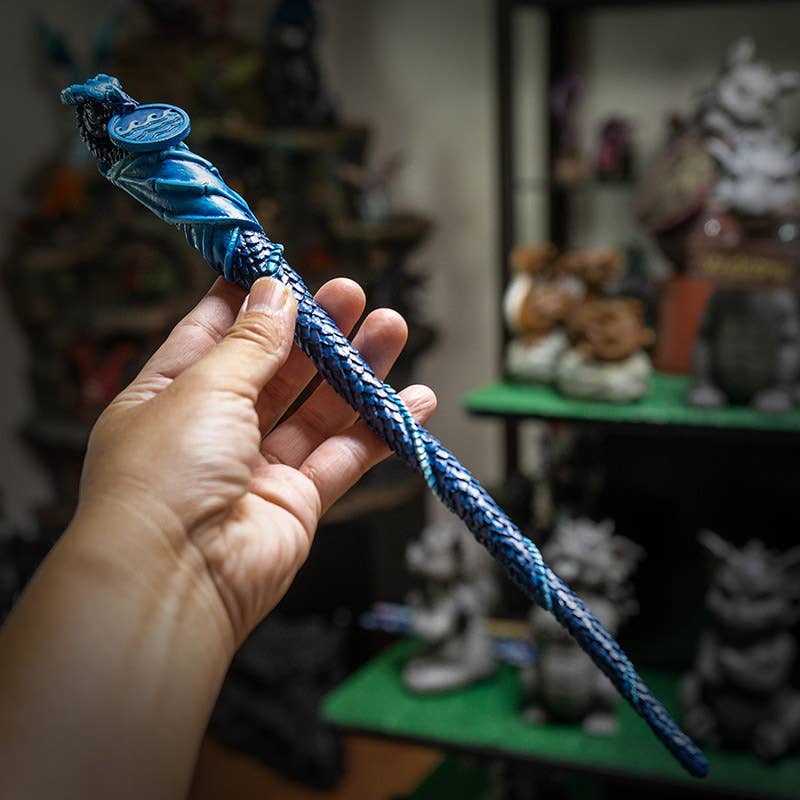 Hand holding a blue braided rope with a blurred background of shelves with figurines.