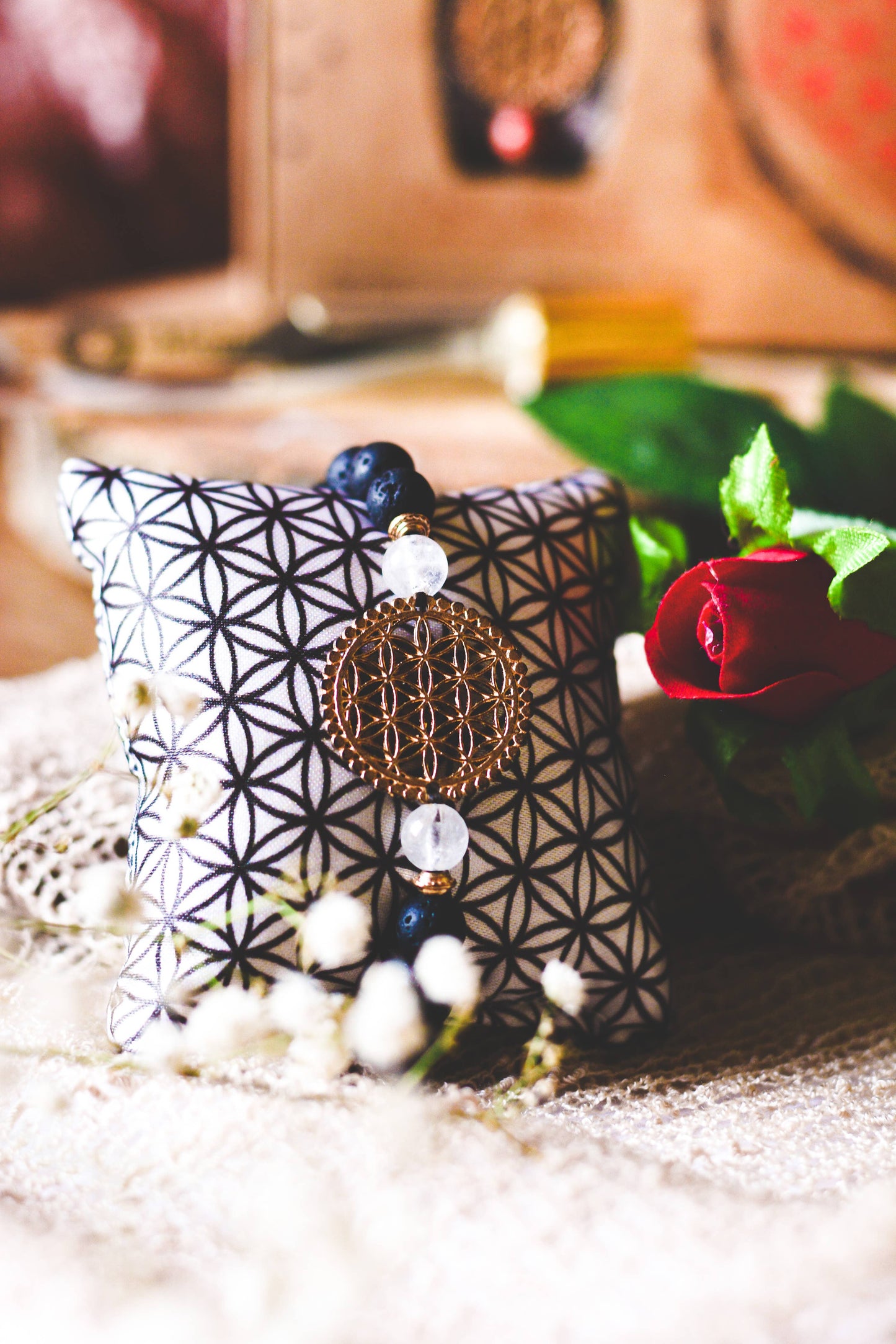 Decorative pillow with geometric pattern and decorative elements on a soft surface.