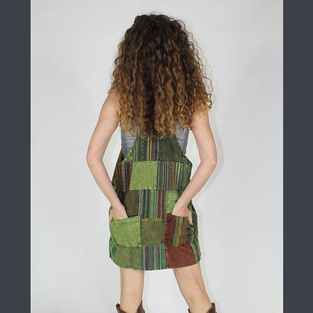 Person wearing a patchwork dress with a neutral background