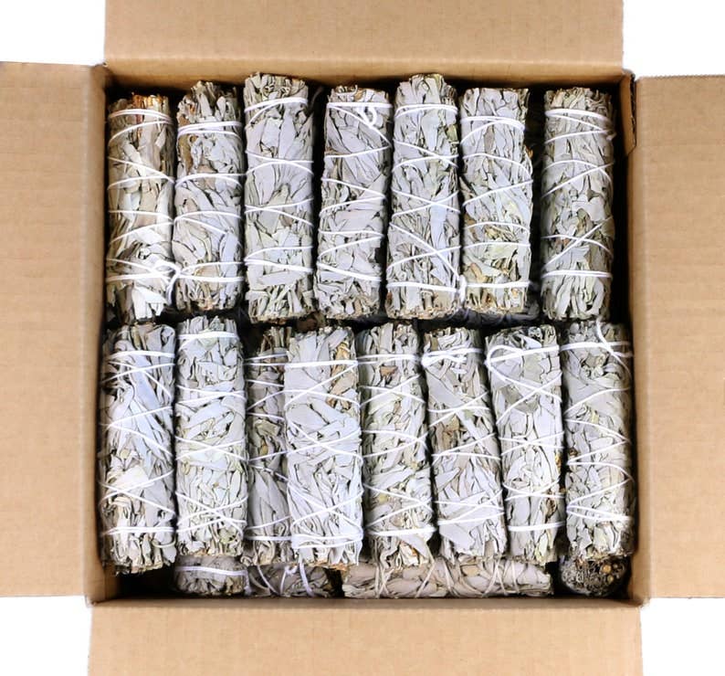 Box of wrapped sage smudge sticks with white twine