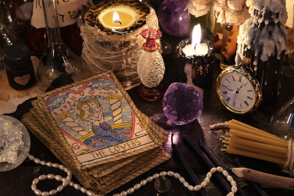 metaphysical table with tarot cards, candles, clock