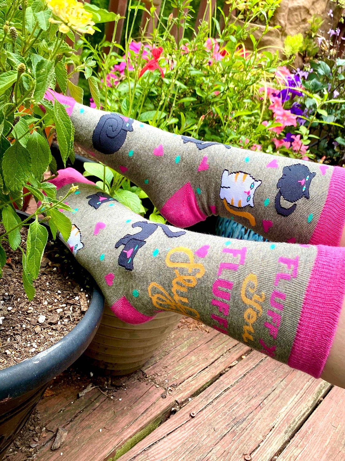 Person wearing colorful socks with animal designs in a garden setting