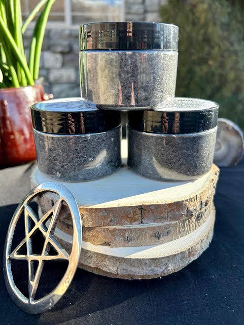 Three metallic containers stacked on a wooden coaster with a pentagram design.