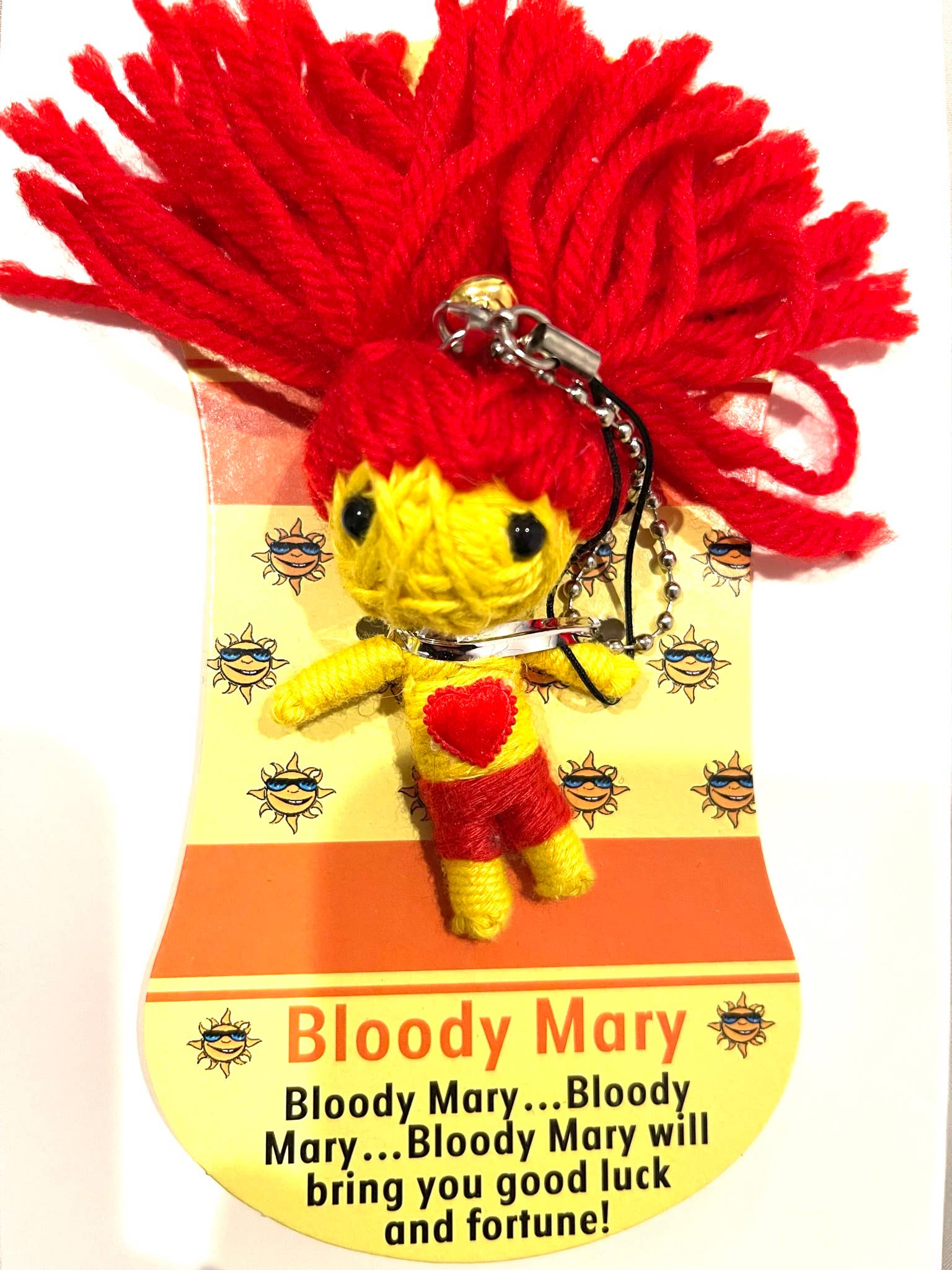 Keychain voodoo doll with red hair and yellow body on a decorative card with text