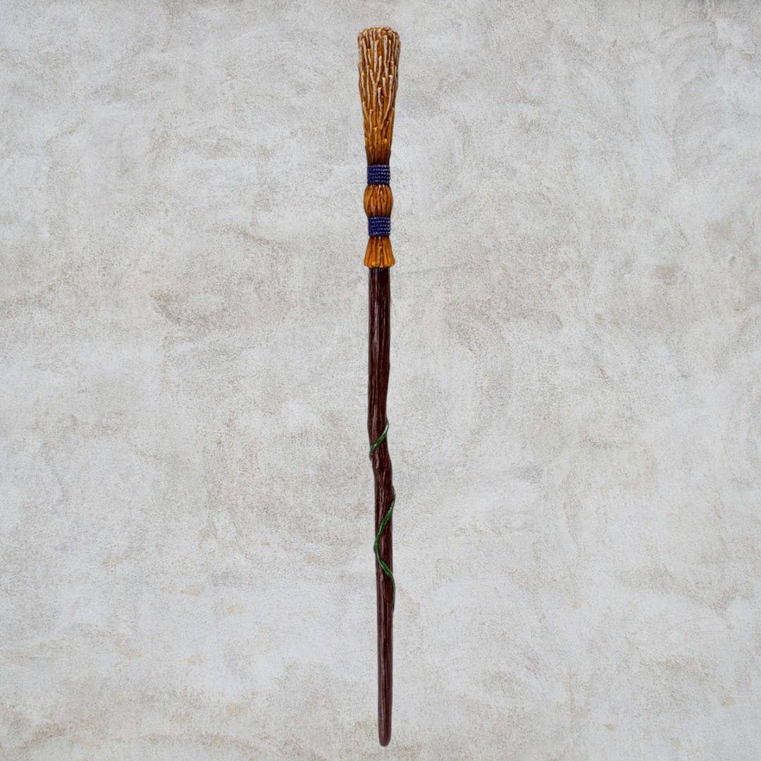 Decorative wand with a textured handle on a light gray background
