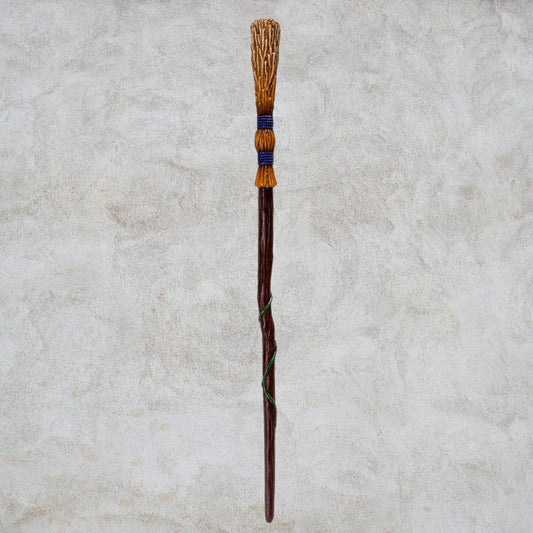 Decorative wand with a textured handle on a light gray background