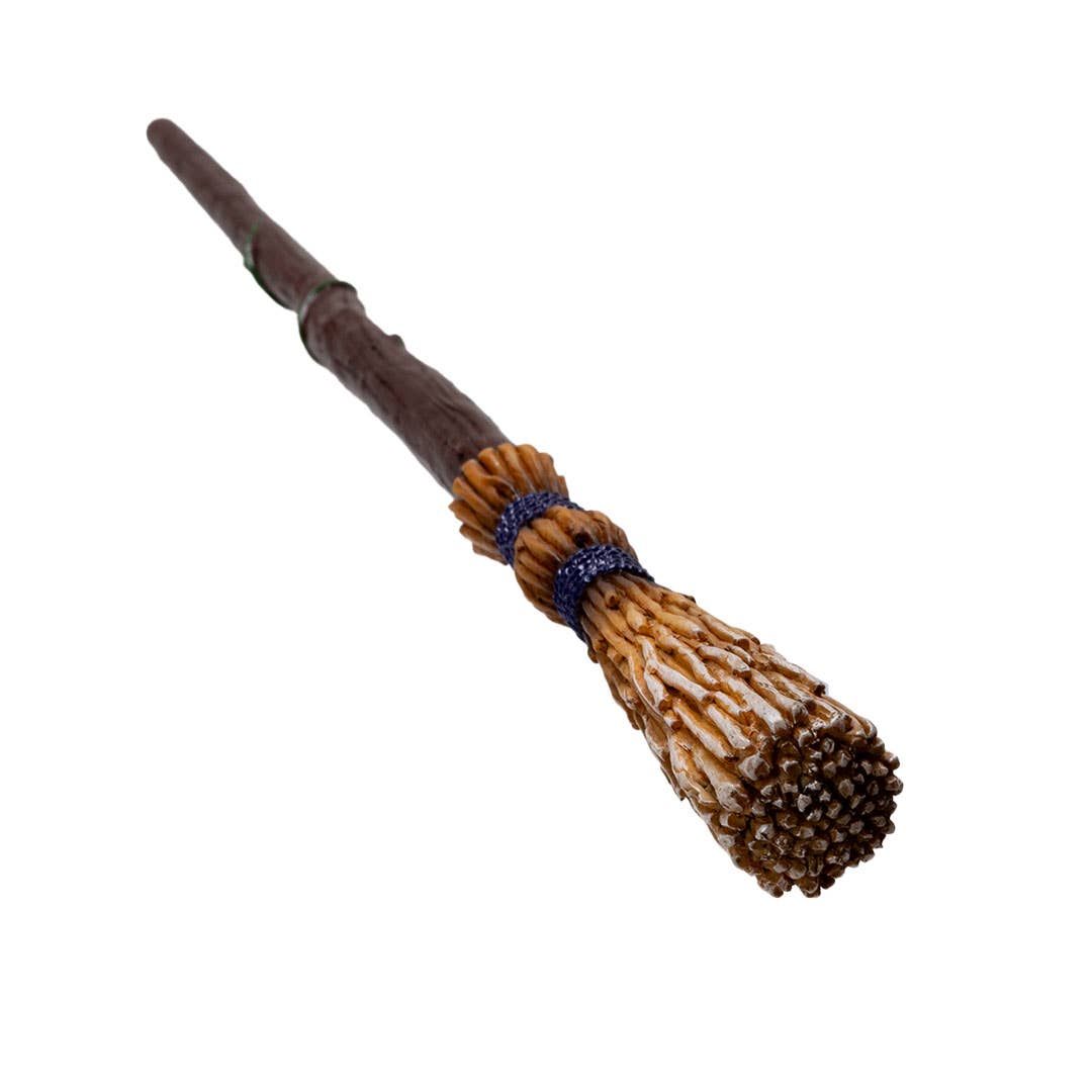Decorative broom with a wooden handle and bristle head on a white background