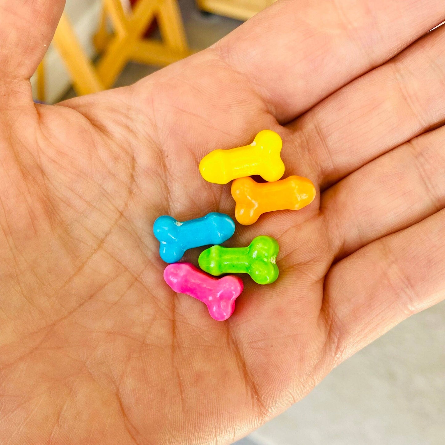 Colorful bone-shaped objects on a hand