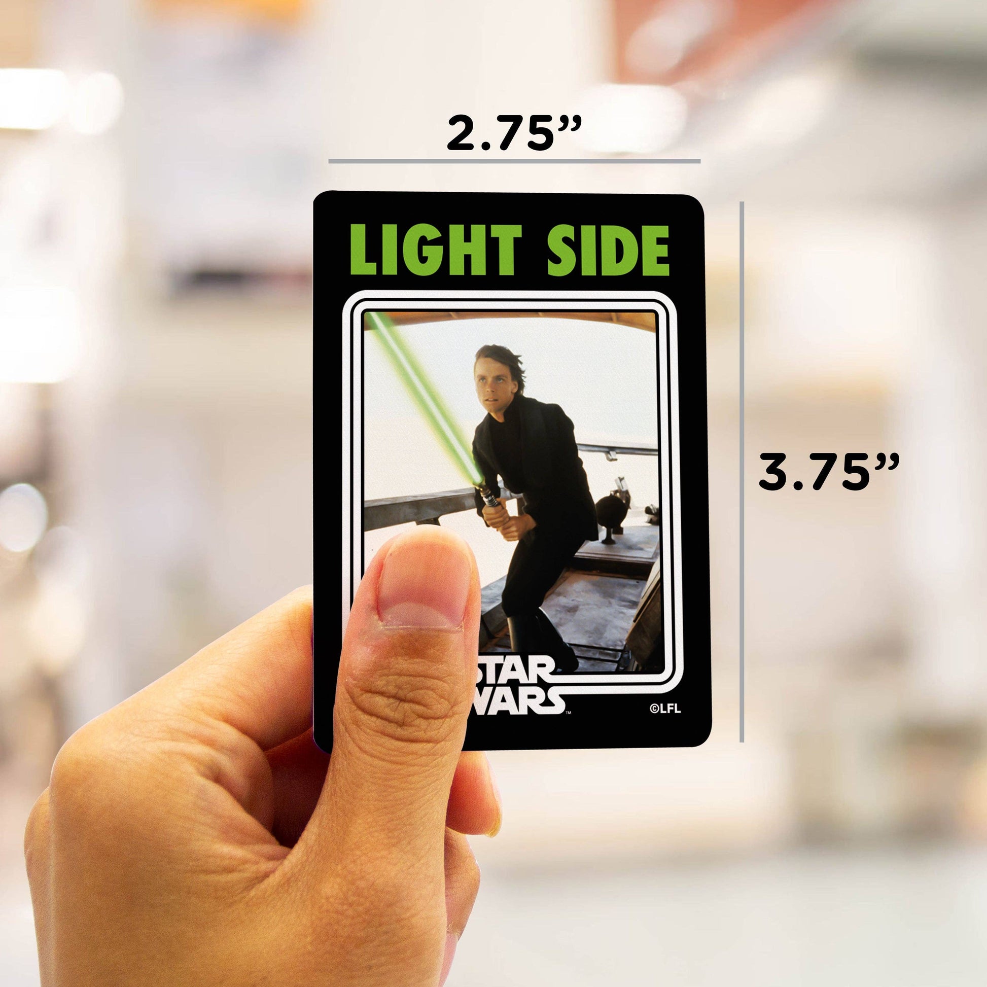 Hand holding a 'Star Wars' card with measurements indicated