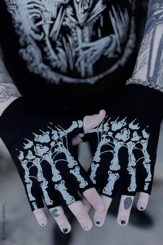 Black gloves with skeleton cat design held by a person with tattoos.