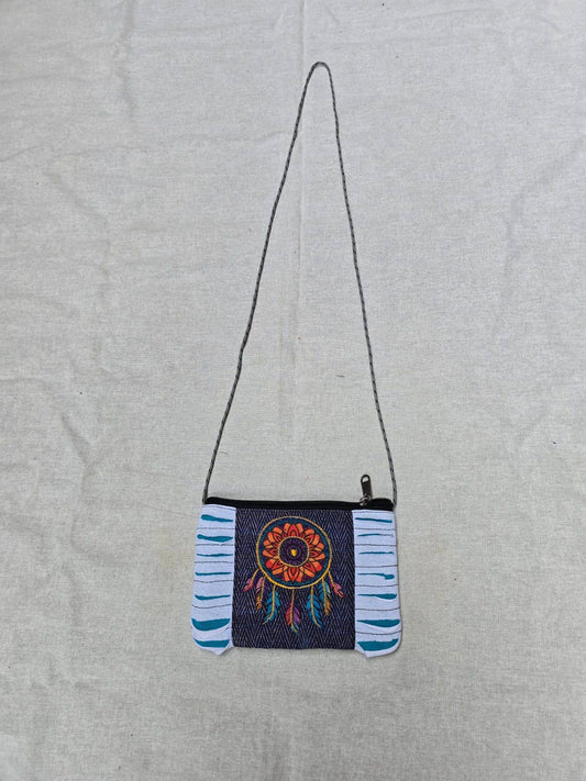 Small crossbody bag with a colorful dreamcatcher design on a light gray background
