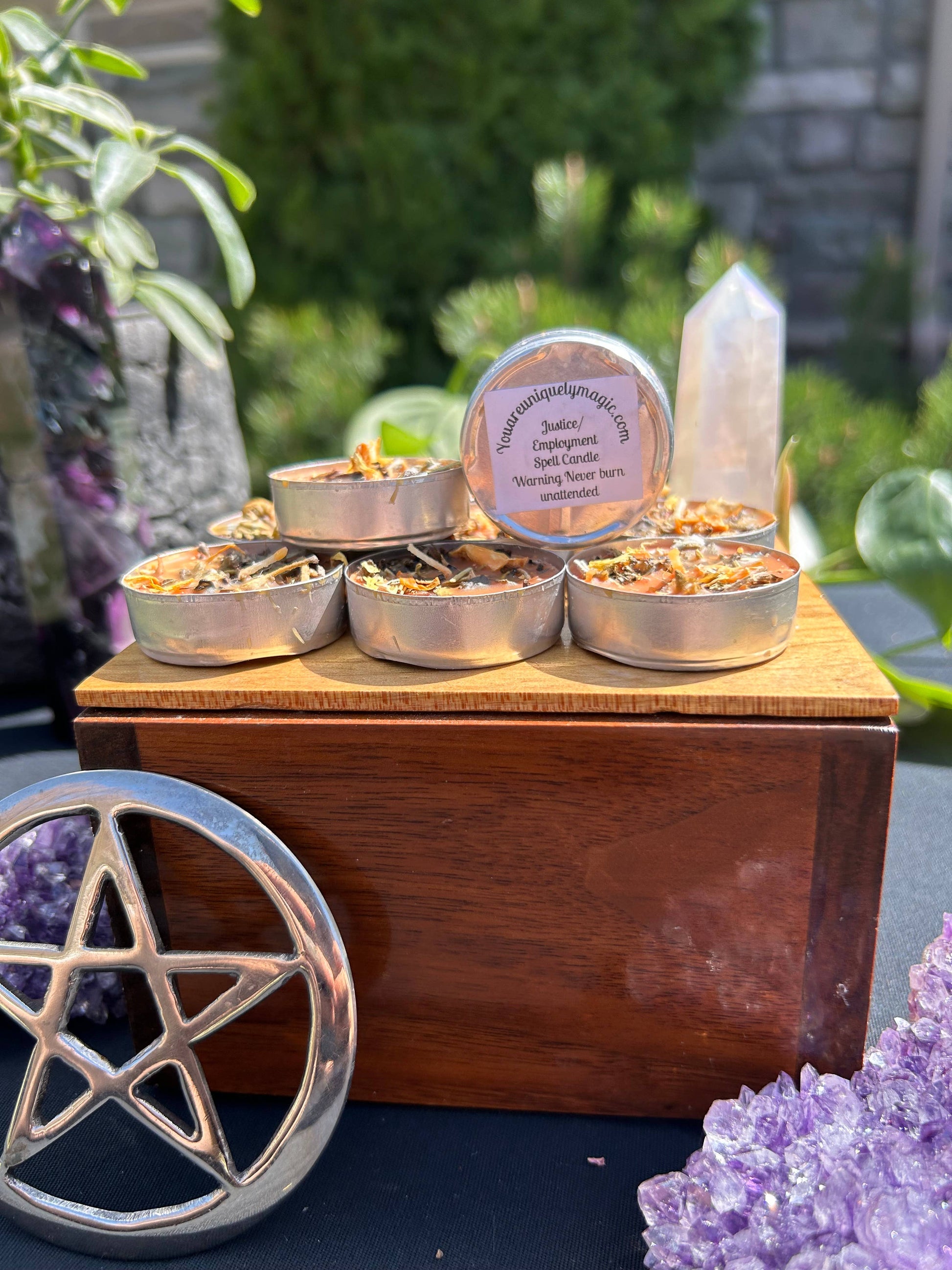 Wooden box with small containers of incense, surrounded by crystals and a pentacle symbol.