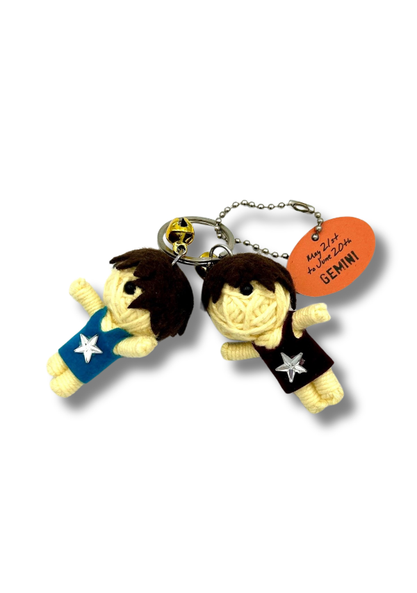 Two small figurines on a keychain with an orange tag labeled 'GEMINI' on a white background