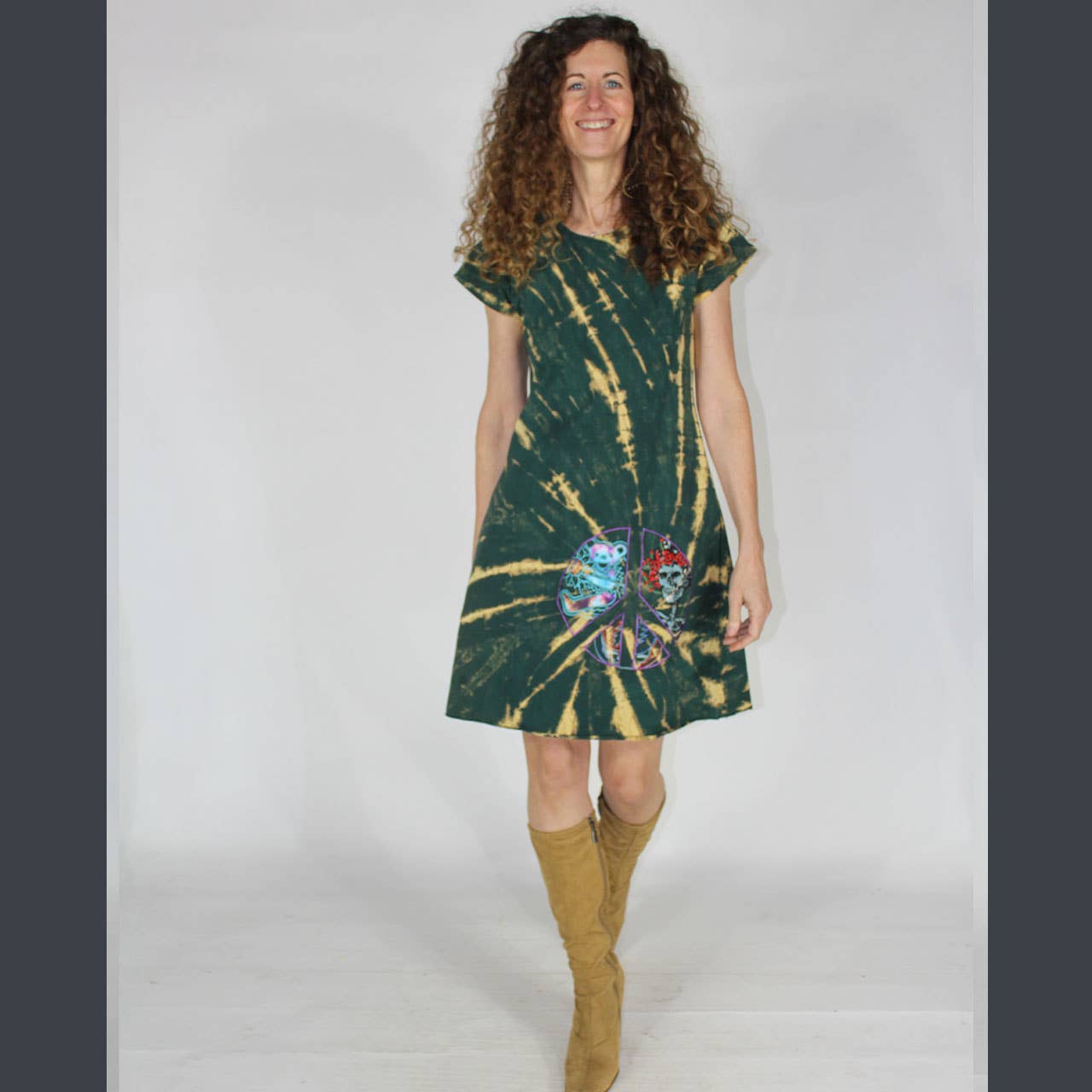 Woman wearing a green and yellow tie-dye dress with a white background