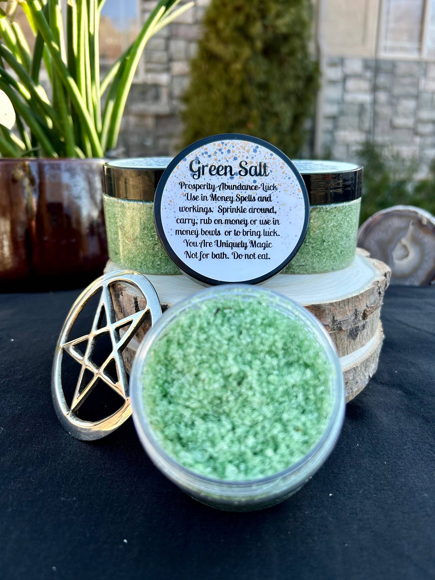 Green salt in a jar with a pentagram symbol and a label on a dark surface.