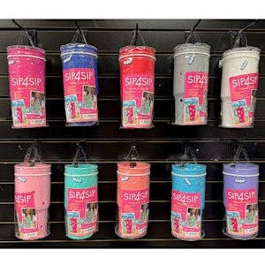 Display of colorful tumblers with 'Sip & Sip' branding on a shelf.