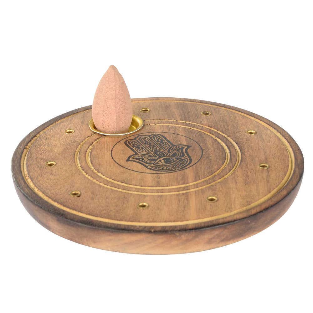 Wooden incense burner with a Hamsa hand design and a cone incense on a white background