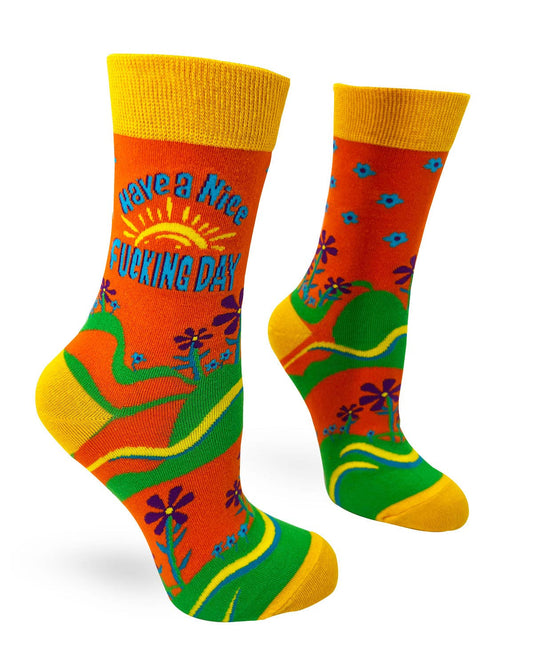 Colorful socks with a humorous message on an orange background