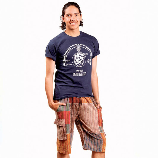 Person wearing a navy blue t-shirt with a graphic design and plaid shorts on a white background