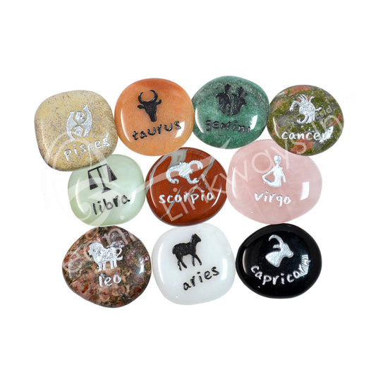 Set of twelve zodiac stones with engraved symbols on a white background