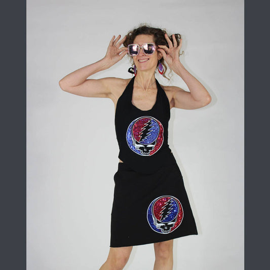 Woman wearing a black dress with Grateful Dead logo on a plain background