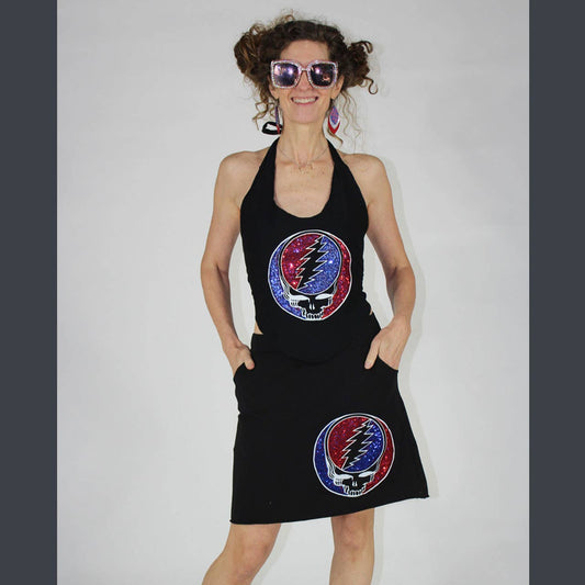 Woman wearing a black dress with Grateful Dead logo on a plain background