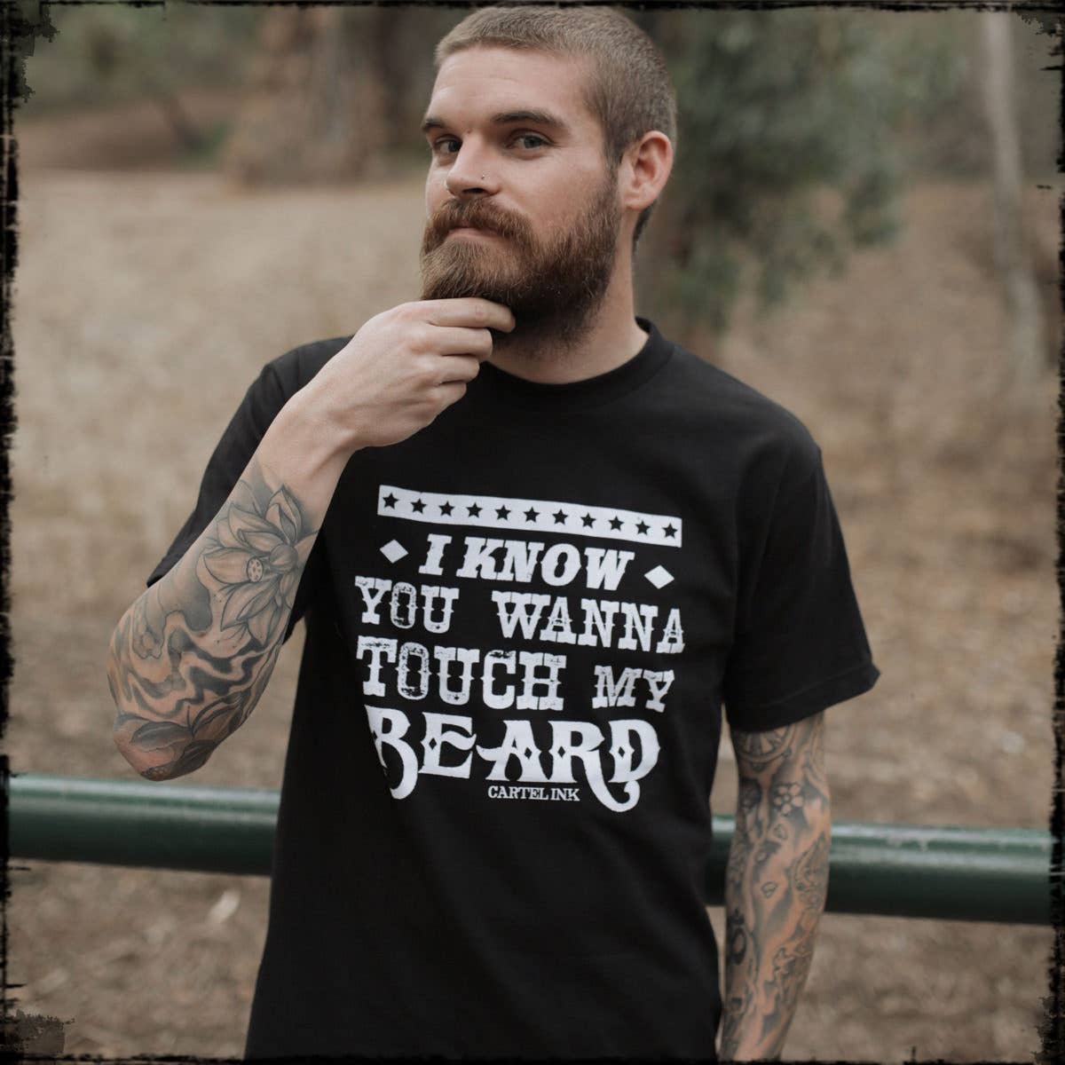 Man wearing a black t-shirt with text, standing outdoors.