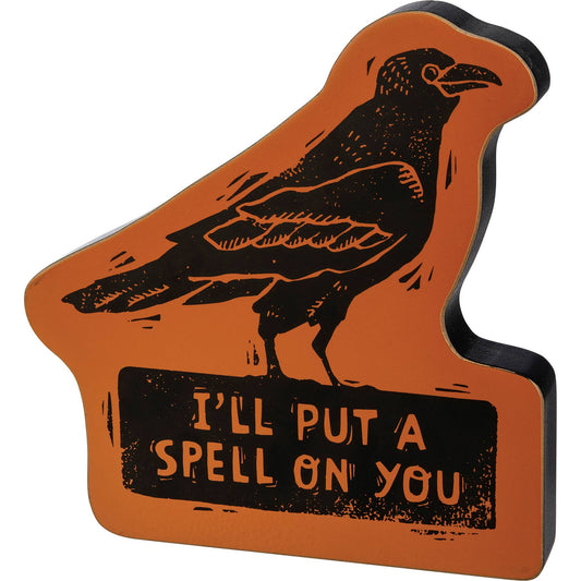 Decorative sign with a crow and text 'I'll put a spell on you' on an orange background