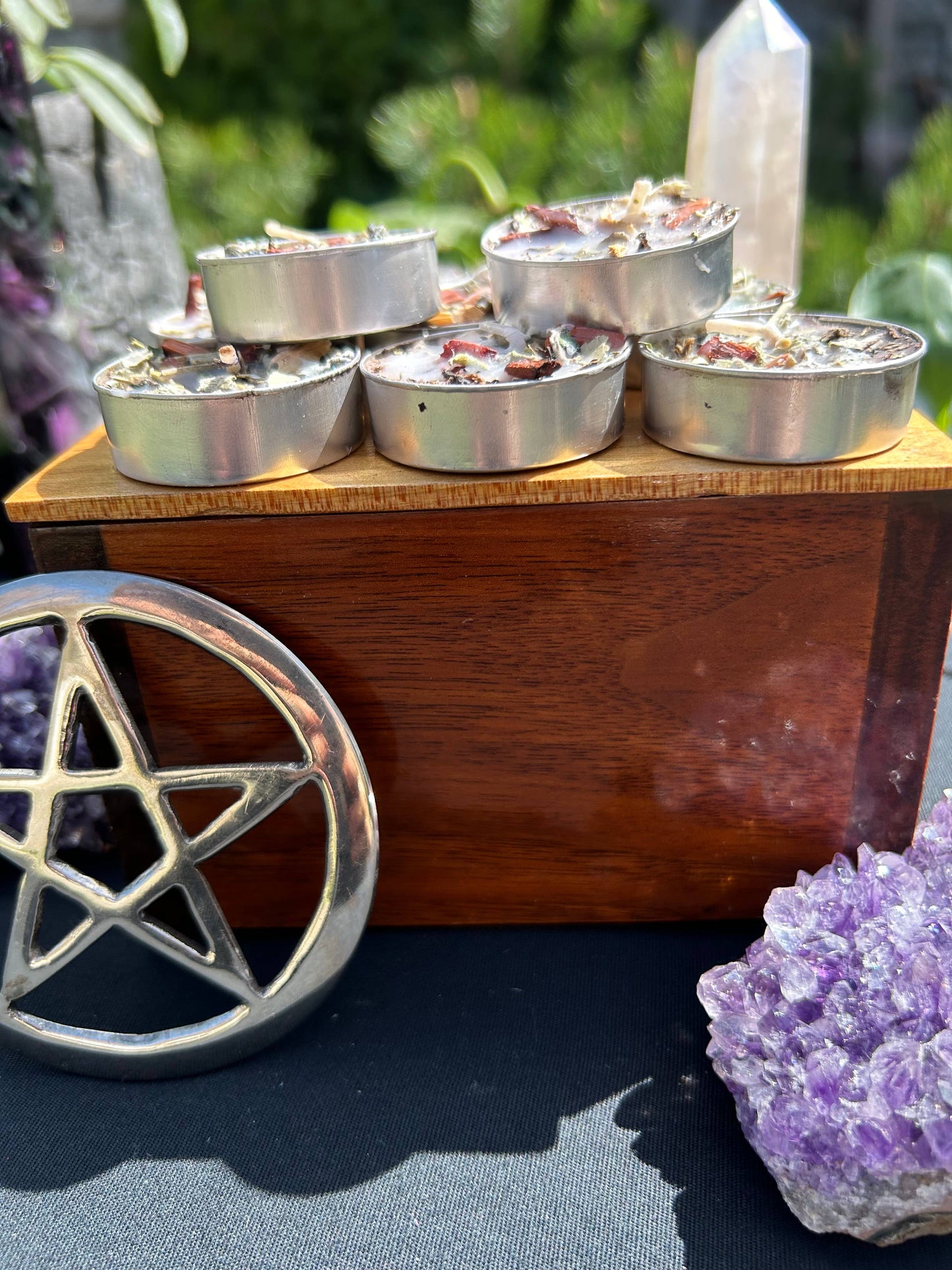 Wooden box with small containers, surrounded by crystals and a pentagram symbol.