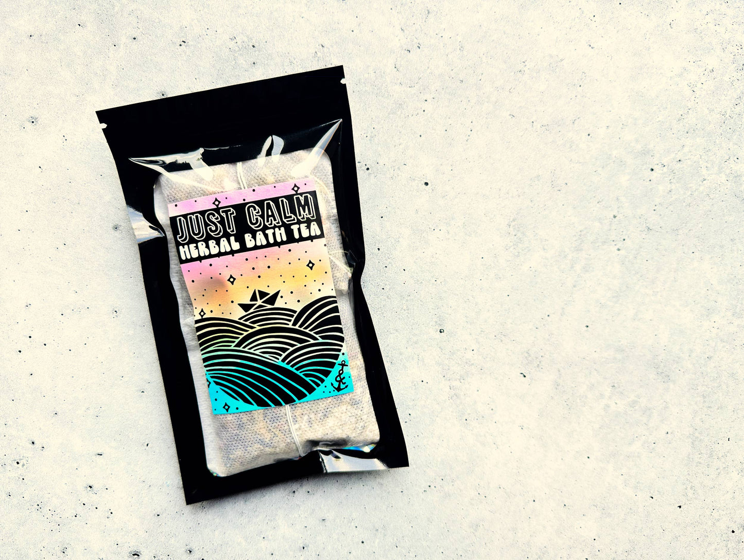 Packaged herbal bath tea with 'Just Calm' label on a textured surface