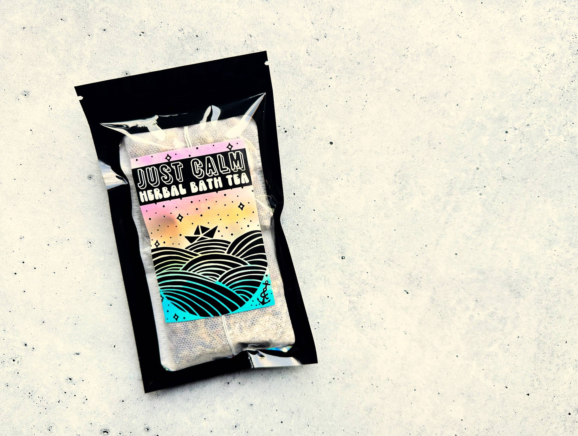 Packaged herbal bath tea with 'Just Calm' label on a textured surface