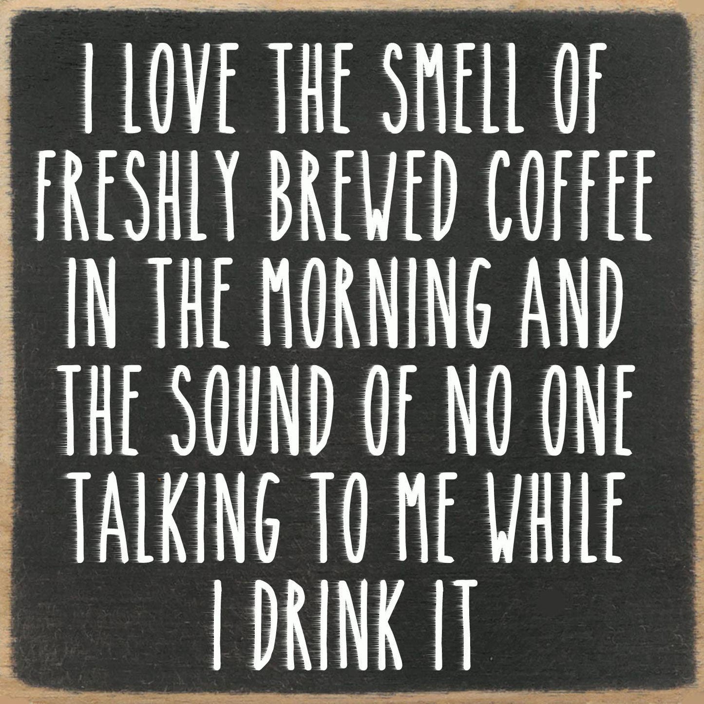 Black square sign with white text about coffee and morning solitude.