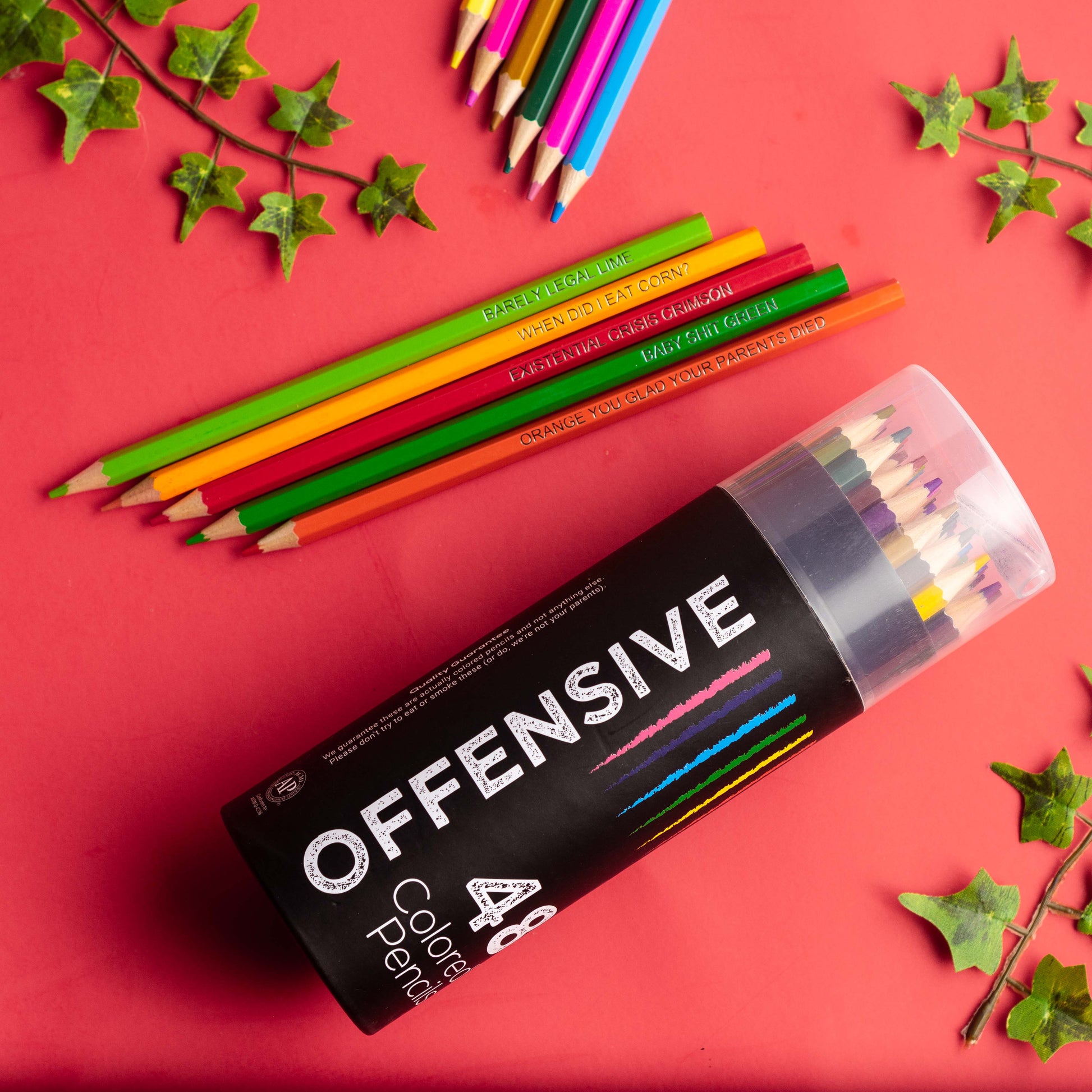 Set of colorful pencils with a box labeled 'OFFENSIVE' on a red background