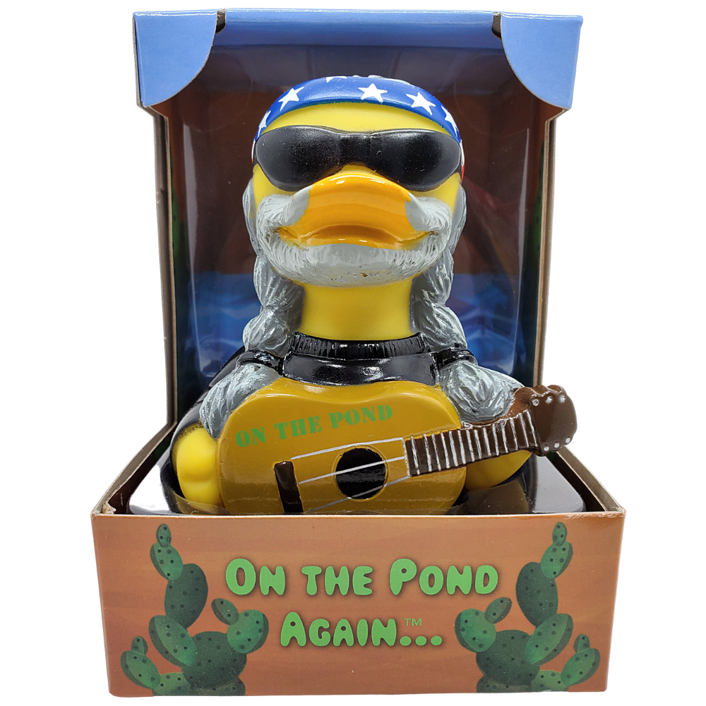 Toy duck with sunglasses, bandana, and guitar in packaging with 'On the Pond Again' text.
