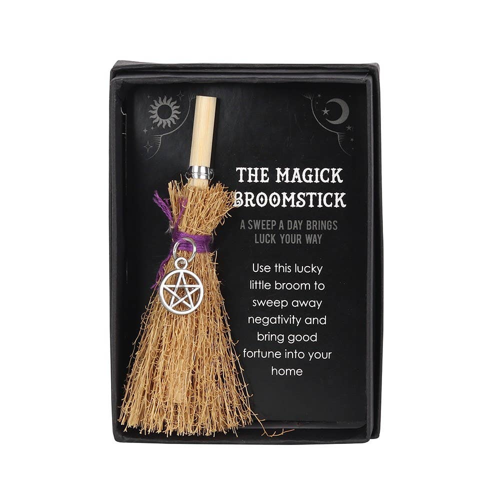 Magick broomstick with pentacle charm in packaging on a white background