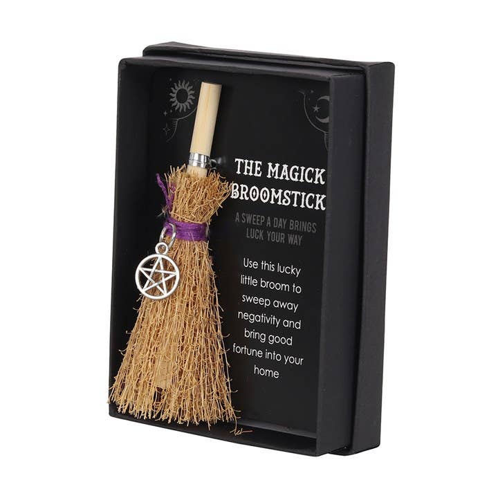 Magick broomstick with pentacle charm in a black box on a white background