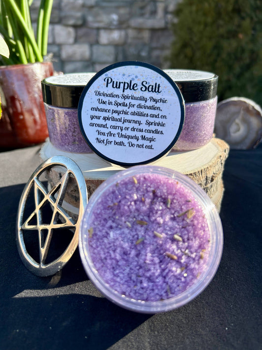 Container of purple salt with a pentagram symbol and label on a dark surface.