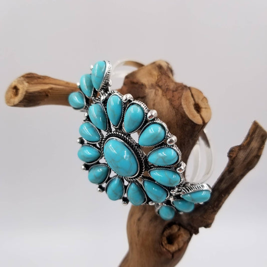 Turquoise stone bracelet on a wooden branch with a white background