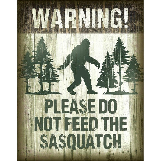 Metal sign with a silhouette of Sasquatch and text 'Warning! Please do not feed the Sasquatch' on a textured background.