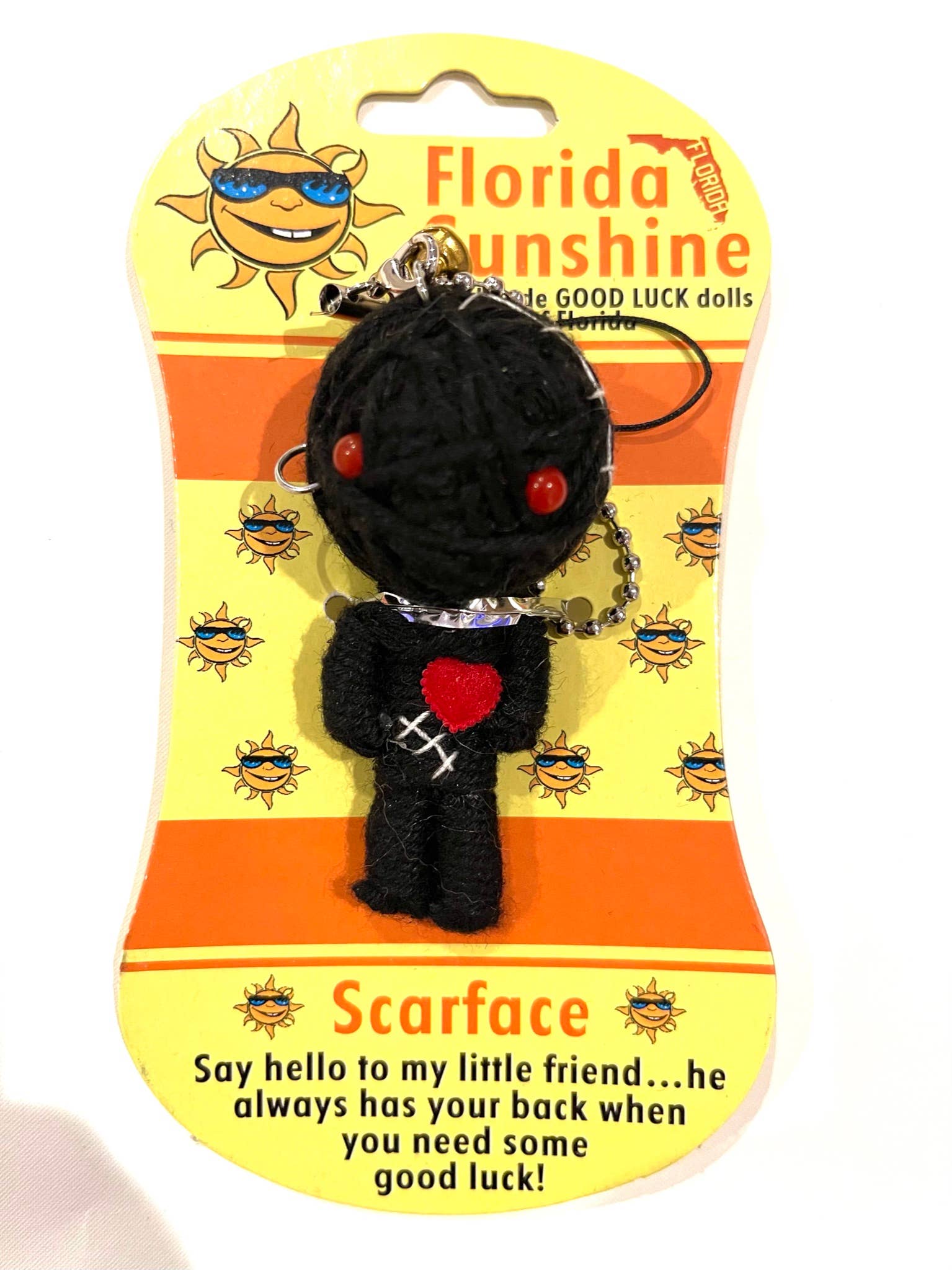 Black voodoo doll keychain with red heart on a Florida Sunshine packaging