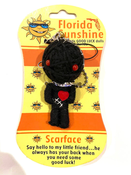 Black voodoo doll keychain with red heart on a Florida Sunshine packaging