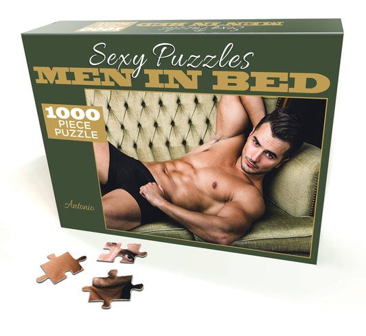 Jigsaw puzzle box titled 'Men in Bed' with a man on a couch, featuring puzzle pieces.