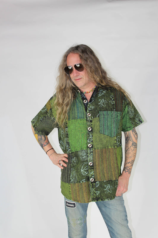Person wearing a patchwork shirt with green and brown patterns on a white background