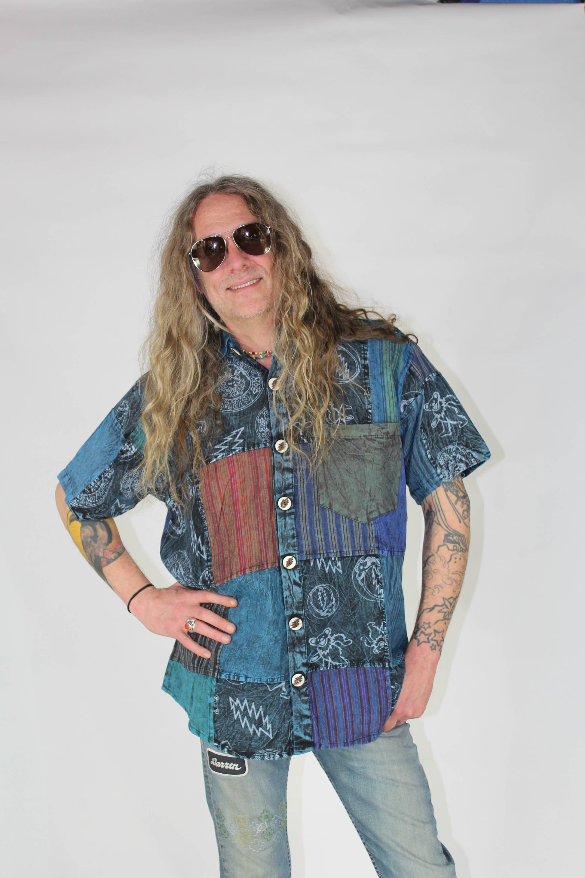 Person wearing a patchwork shirt and sunglasses on a white background