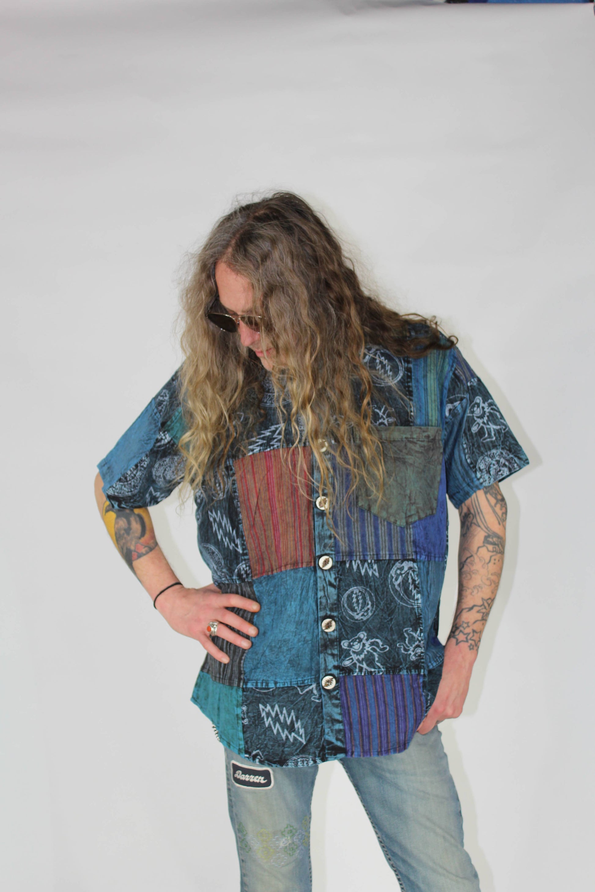 Person wearing a patchwork shirt with a plain background