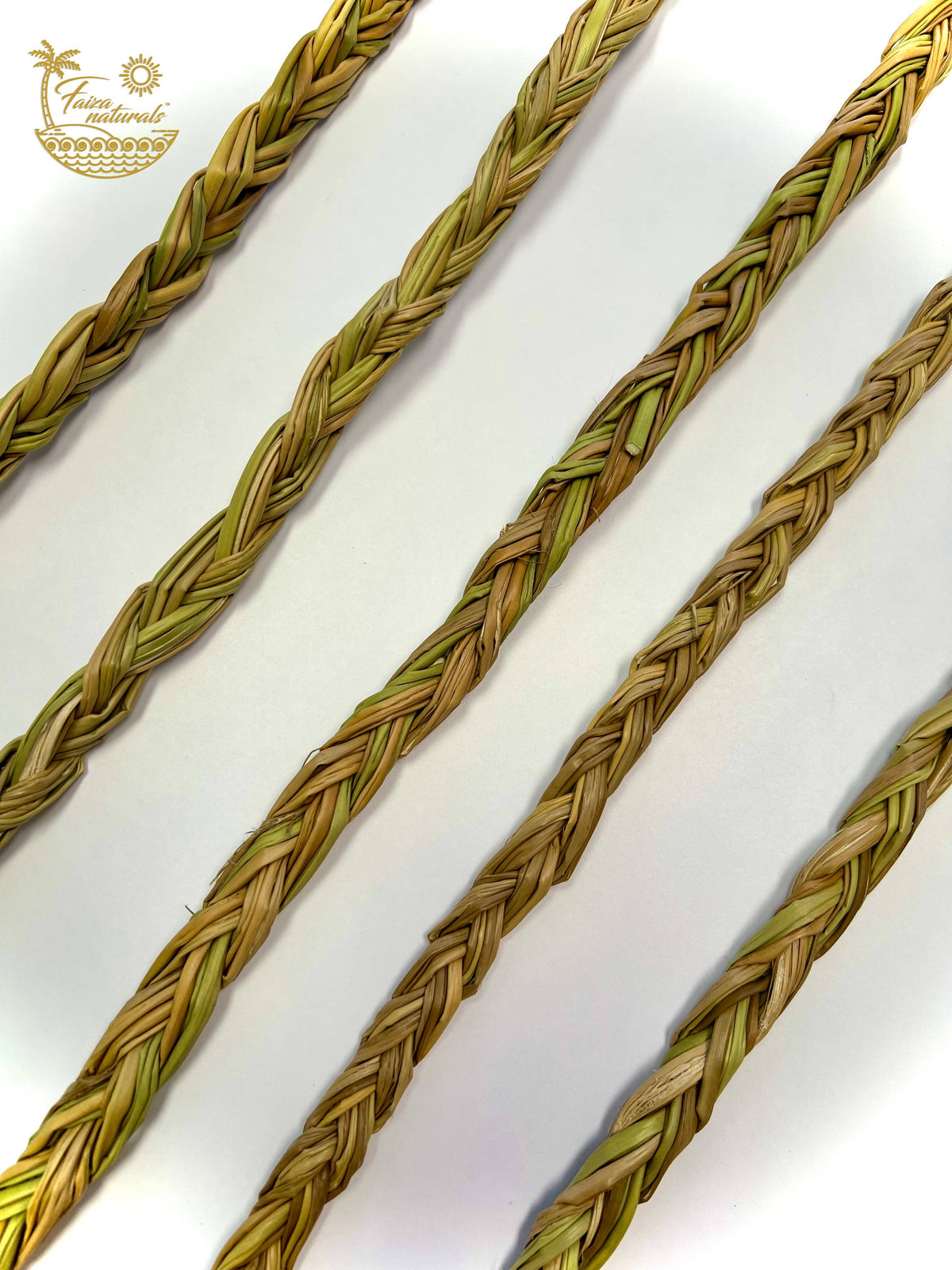 Four braided natural fiber cords, likely palm leaves or raffia, arranged diagonally on a white background. A gold logo for 'Tina y sus materiales' is visible in the top left corner.