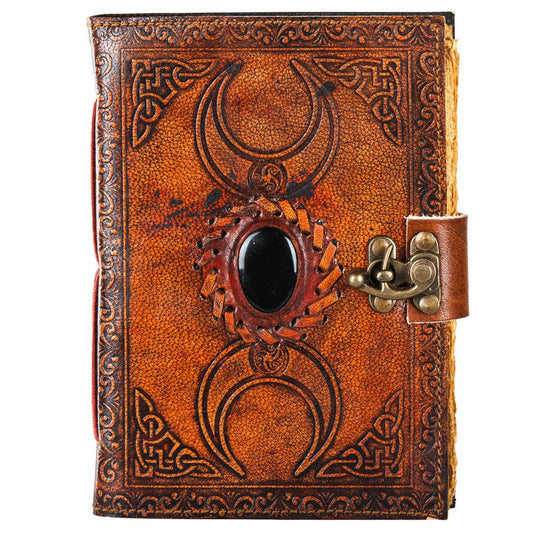 Decorative leather journal with embossed designs and a latch on a white background