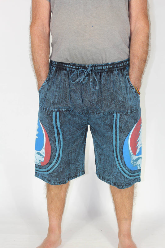 Person wearing blue denim shorts with graphic designs on a white background