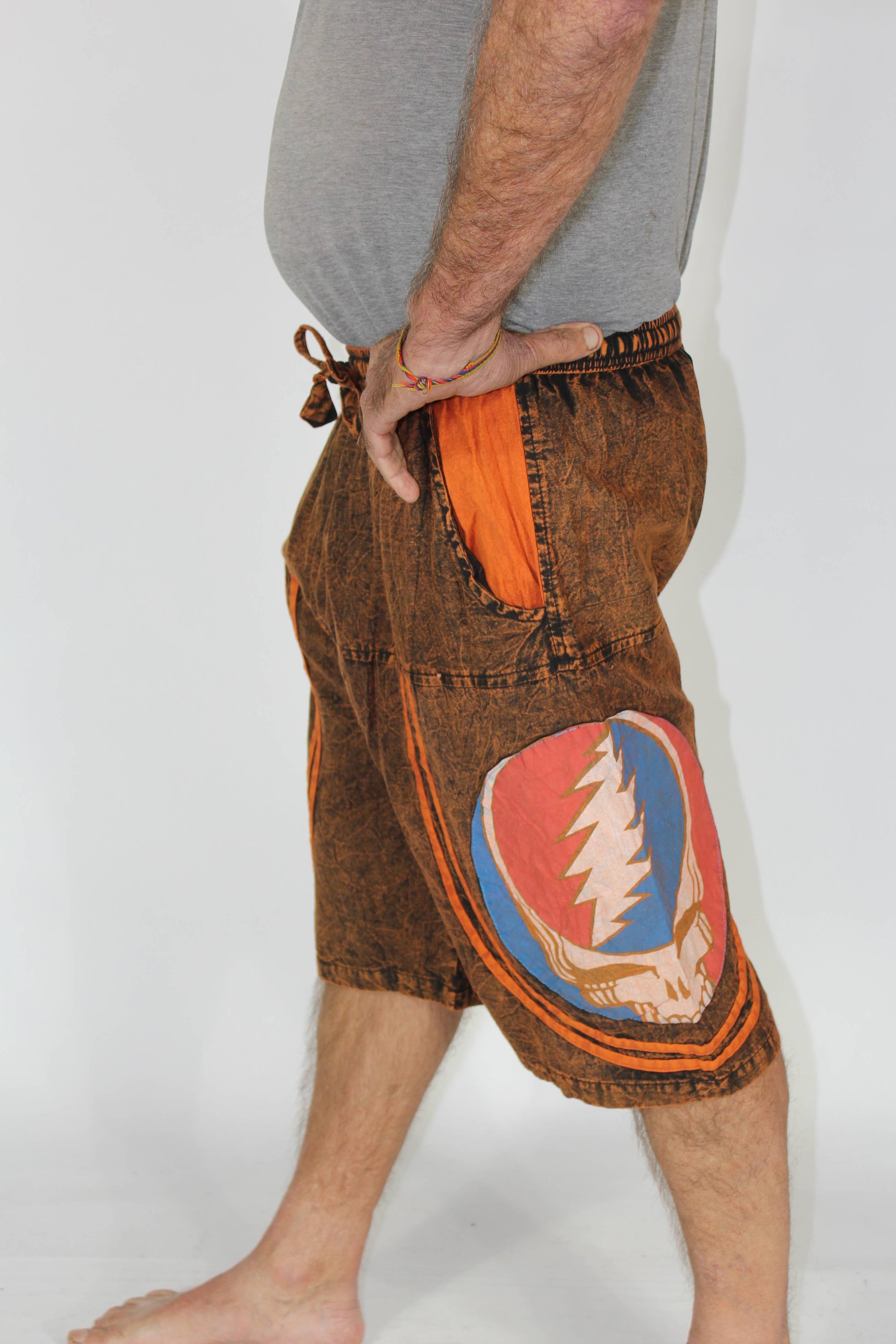 Brown shorts with a colorful graphic design on a white background